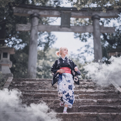 1girl, solo, lazypos, delicate, dreamy, from front, low angle, cinematic lighting, cinematic, volumetric lighting, natural shadows, [clouds:7], blue sky, soft and gentle colors, soft pastel colors, soft shading, detailed textures, kaela20, blonde hair, red eyes, folded ponytail, smile, lace_trimmed_skirt, kimono_jacket, black jacket, white kimono, print kimono, blue skirt, long skirt, sandals, white socks, red sash, obi, flower print kimono, stone stairs, torii, forest, walking on stairs, hands on stomach, looking away, usnr, , dynamic pose, foreshortening, extreme perspective